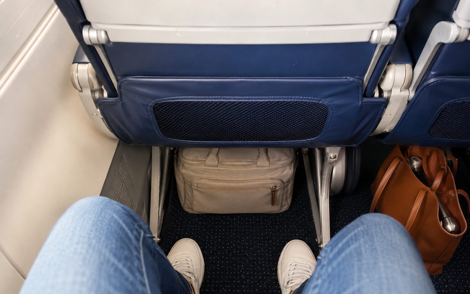 Personal item bag under an airplane seat