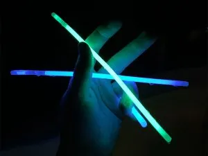 Blue and Green glow sticks held in hand