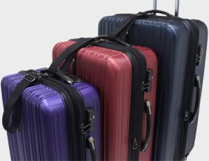 Luggage set hooked together on a gray background